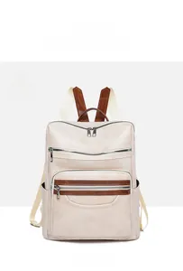 Detailed front view of off-white PU leather backpack with brown trim and multiple pockets