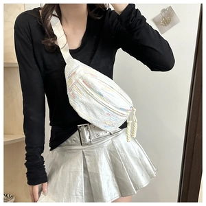 Détail du sac bandoulière blanc texturé avec broderies colorées et pompon soigné