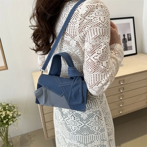 Chic patchwork denim tote bag with white stitching and knotted handle shown on shoulder