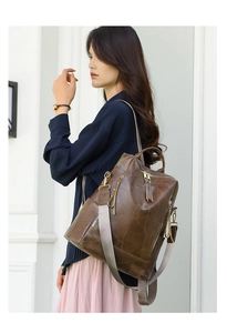 Detail of dark brown vintage PU leather backpack with geometric texture and gold hardware