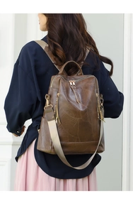 Detail of vintage brown PU leather backpack featuring anti-theft zipper and wide strap
