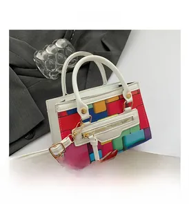 Detail view of colorful geometric block pattern and white PU leather handle on handbag