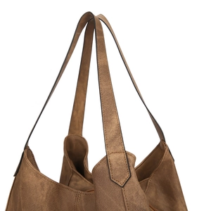 Detailed close-up of dark brown tote bag with matte texture and dual shoulder straps
