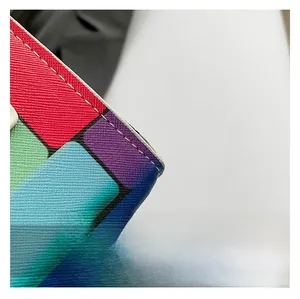 Detailed close-up of Saffiano leather texture with geometric patchwork and white stitching