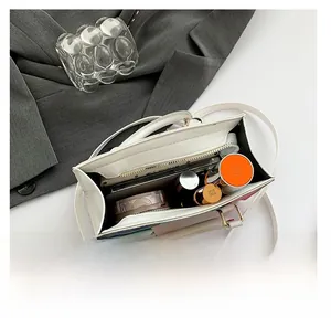 Detail showing internal capacity of the white leather handbag with daily essentials