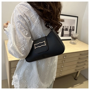 Chic black hobo underarm bag with gold metal buckle shown on model in indoor setting
