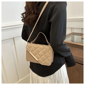 Sac à main matelassé beige avec détails dorés porté par un mannequin en vue arrière
