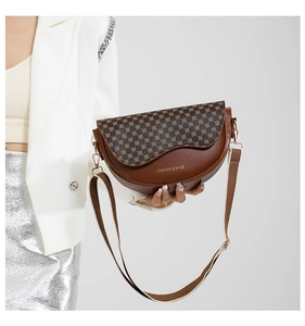 Braune Satteltasche mit gemusterter Klappe und breitem Gurt, von Model gehalten