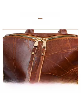 Detail of premium gold metal zippers on vintage brown faux leather backpack with texture