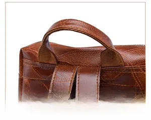 Detail of the brown PU leather backpack top handle with reinforced stitching