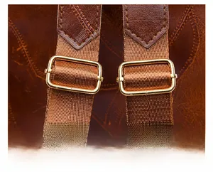 Detail of adjustable brown shoulder strap with golden metal buckle and faux leather texture