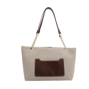 Beigefarbene Canvas-Einkaufstasche mit brauner Ledertasche und goldener Kette in Frontalansicht