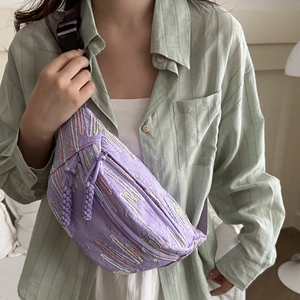 Sac à bandoulière brodé violet avec tissu texturé et sangle réglable assortie