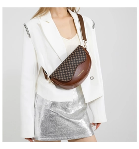 Detail einer braunen Satteltasche mit Leopardenmuster, breitem Gurt und goldener Hardware