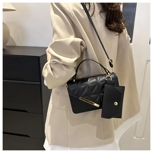 Detail of black quilted shoulder bag with gold hardware and detachable coin purse