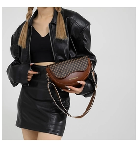 Nahaufnahme braune Satteltasche mit Vintage-Print, breitem Gurt und goldenem Metall