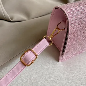 Detail aus rosa Glitzerstoff und goldenem Metallverschluss an einer schicken Mini-Kettentasche
