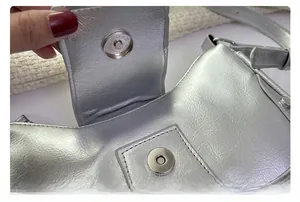 Detail shot of the magnetic snap closure and silver metallic pleated leather texture
