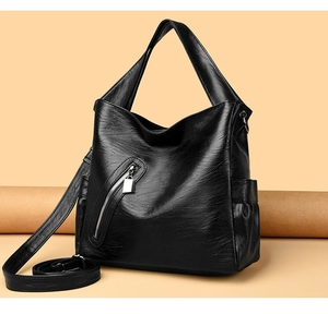 Detail of black large capacity shoulder bag showing soft PU leather and metal zipper pocket