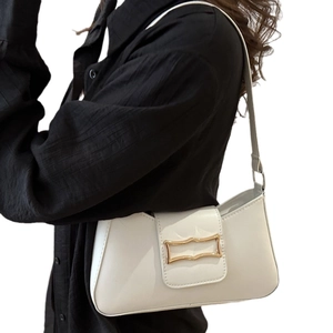 Chic white patent leather underarm bag with gold wavy buckle and slim shoulder strap