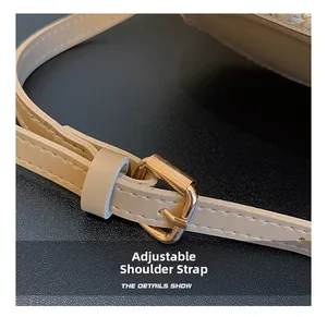 Détail de la bandoulière réglable en cuir avec une boucle rectangulaire dorée chic