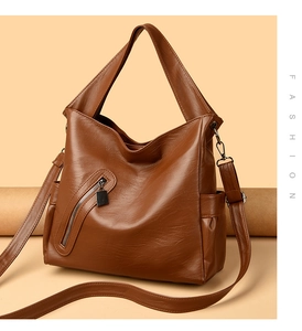 Detail of caramel brown tote bag featuring lychee texture and metallic zipper pocket