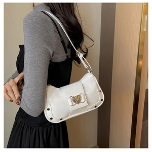 Detail of white glossy leather crescent bag with heart buckle and silver rivets
