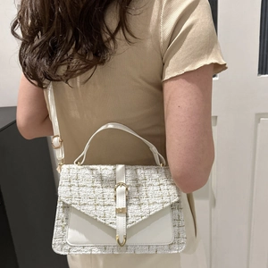 White plaid tweed crossbody bag with gold hardware shown worn over the shoulder