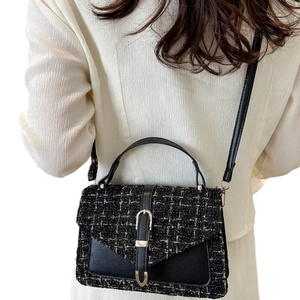 Women's black tweed crossbody bag with gold hardware and leather details
