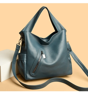 Detailed view of matte leather shoulder bag featuring a decorative diagonal zipper and pendant
