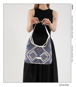 Detail of ethnic geometric patterned tote bag with white leather strap on female model