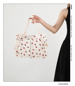 Détail du sac cabas en velours côtelé blanc à motifs de fraises et deux poches avant