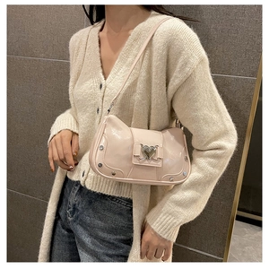 Detail of pink glossy shoulder bag with silver heart buckle and decorative rivets