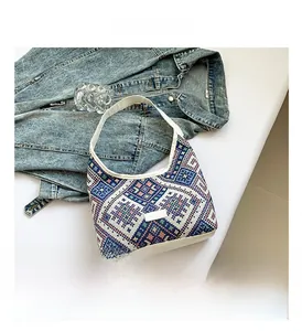 Close-up of geometric jacquard ethnic pattern and cream leather strap on canvas tote bag