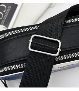 Gros plan sur la bandoulière large en nylon réglable avec boucle argentée sur sac noir
