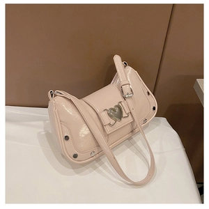Detail of glossy beige shoulder bag featuring heart buckle and silver rivets