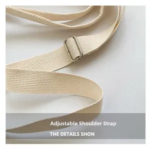 Détail de la bandoulière réglable en toile crème avec boucle métallique robuste