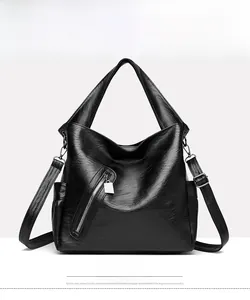 Front view of black soft leather tote bag with functional zippers and detachable strap