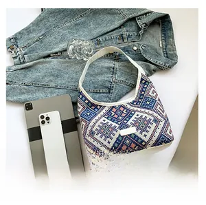 Ethnic geometric tote bag with white PU strap laid with a tablet and phone on white desk