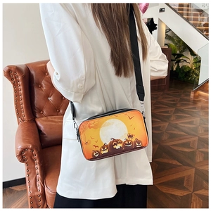 Detail of Halloween crossbody bag featuring pumpkin and bat patterns with wide strap