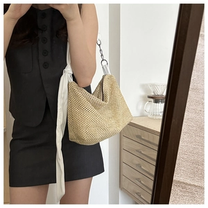 Detail of woven straw tote bag with elegant white knotted silk shoulder strap for women