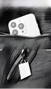 Detail of the back zipper pocket on black lychee leather tote with a silver metal puller