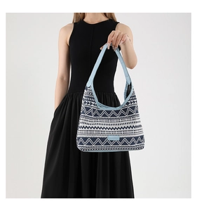 Close-up of geometric pattern on ethnic canvas tote with blue leather strap detail