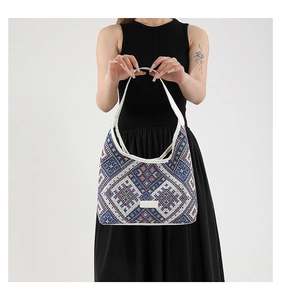 Detail of bohemian geometric woven fabric texture and white leather strap on tote bag