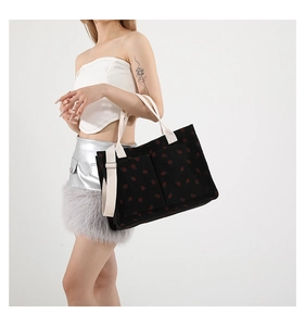 Détail du sac cabas en velours côtelé avec imprimé fraise et poches avant pratiques