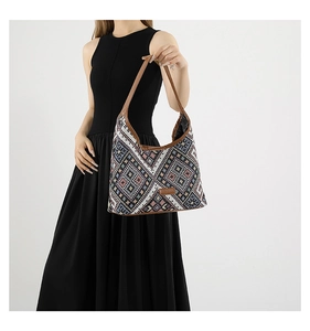 Close-up of geometric woven pattern and brown leather strap on a large ethnic tote bag