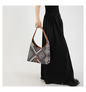 Detail of bohemian woven tote bag with colorful geometric patterns and brown shoulder strap