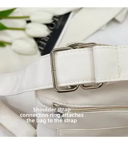 Detailaufnahme der cremefarbenen Canvas-Tasche mit Fokus auf Trageriemen und Metallbeschlägen
