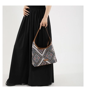 Detail of bohemian geometric woven tote bag with brown leather trim and shoulder strap
