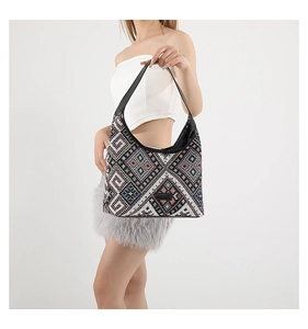 Close-up of ethnic geometric jacquard weaving and premium black leather trim on tote bag